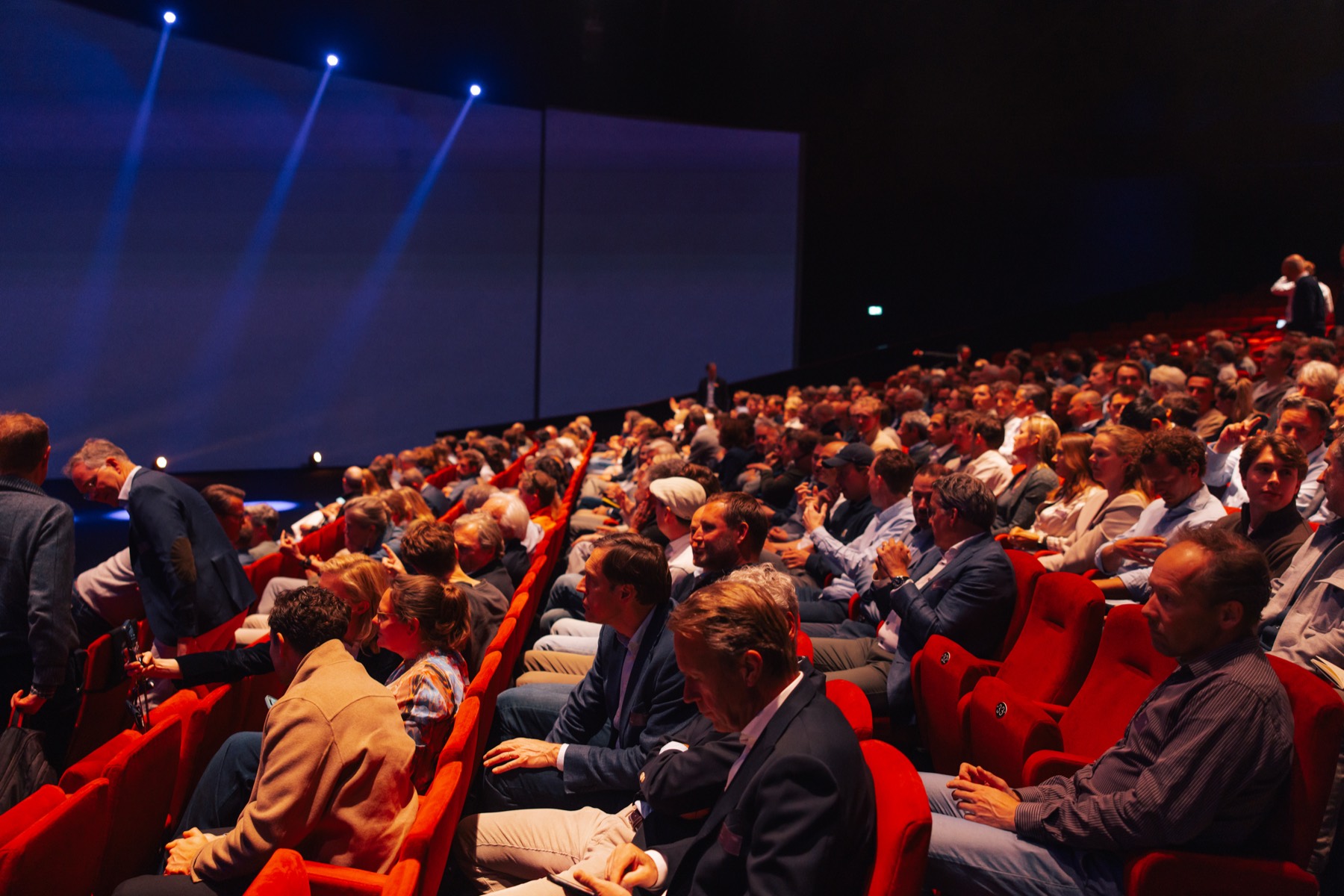 Full audience in red theatre seats during a keynote